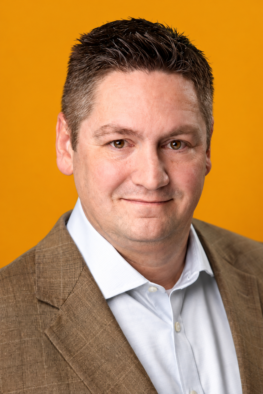 Adam Frisbee wearing a brown blazer